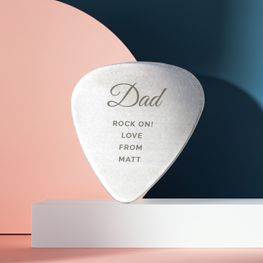 Personalized silver guitar pick with engraved message on a colorful background