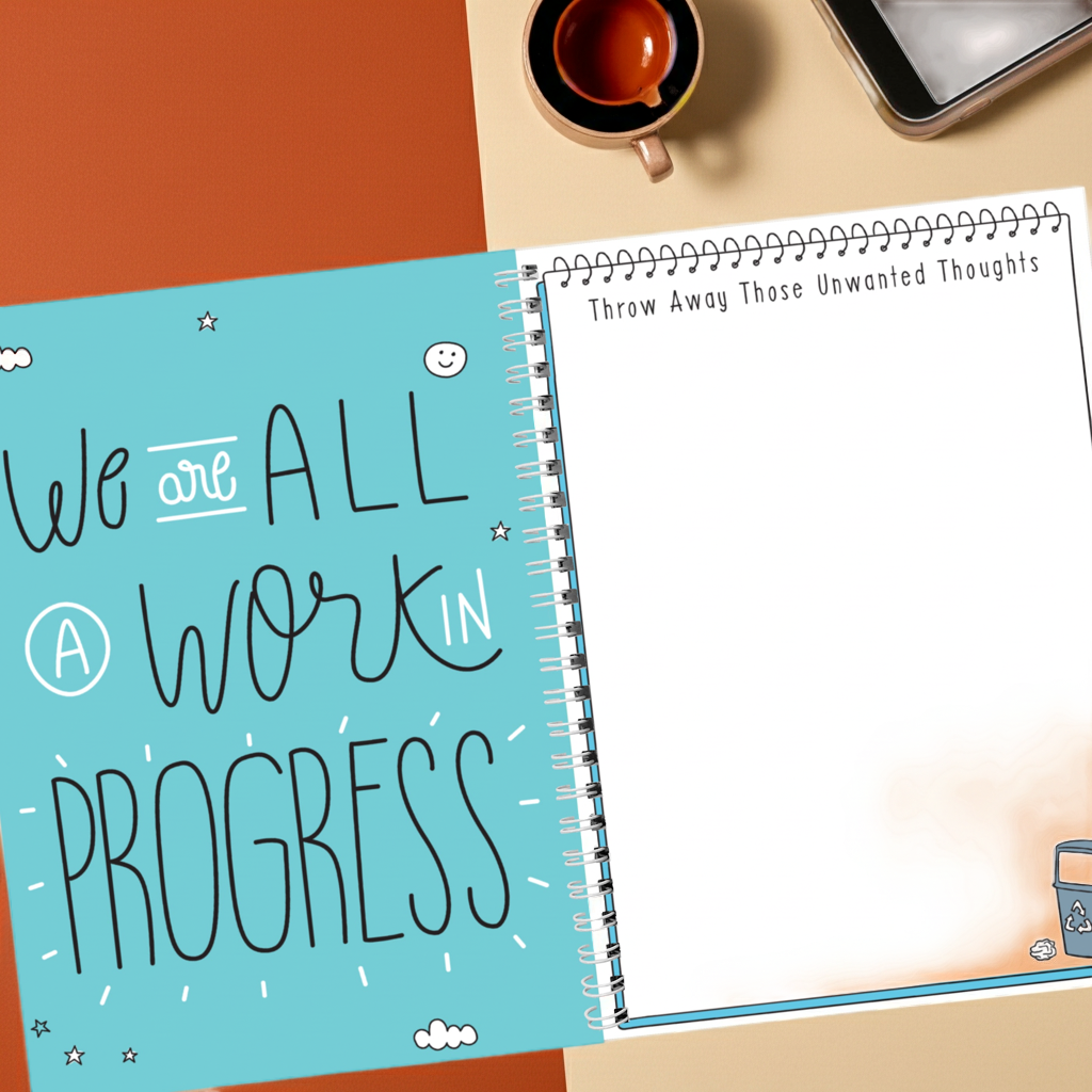 Notebook with motivational quote on a desk with a cup and phone
