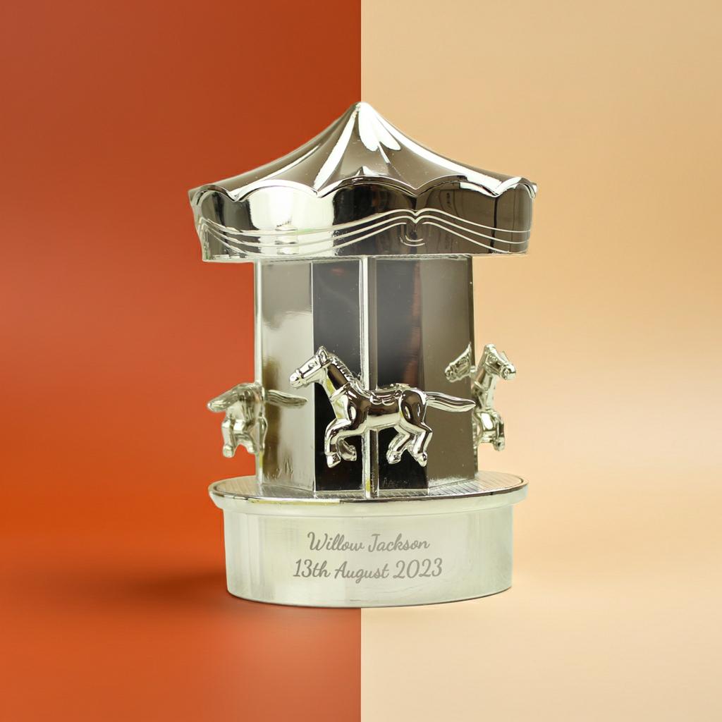 Decorative silver carousel figurine with engraved text on a two-tone background
