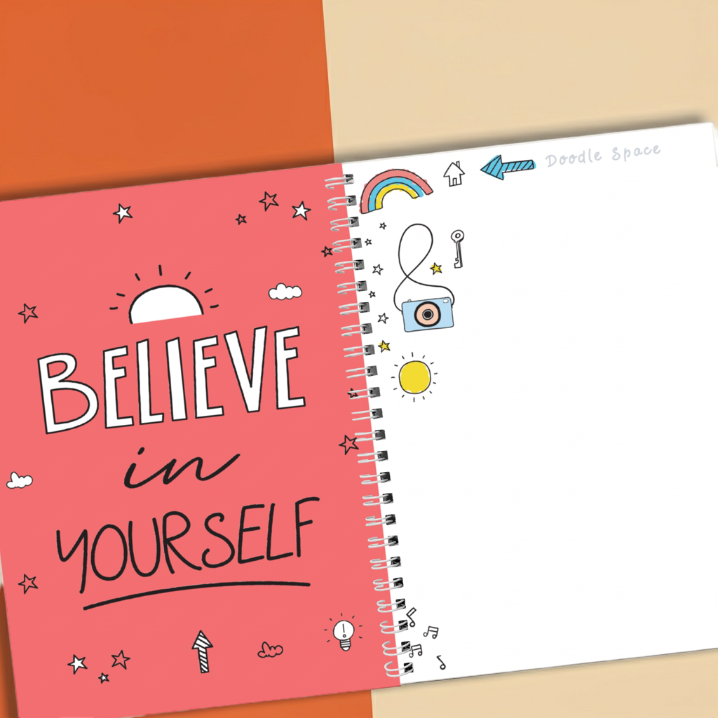 Notebook with 'Believe in Yourself' on pink cover and doodles on white page