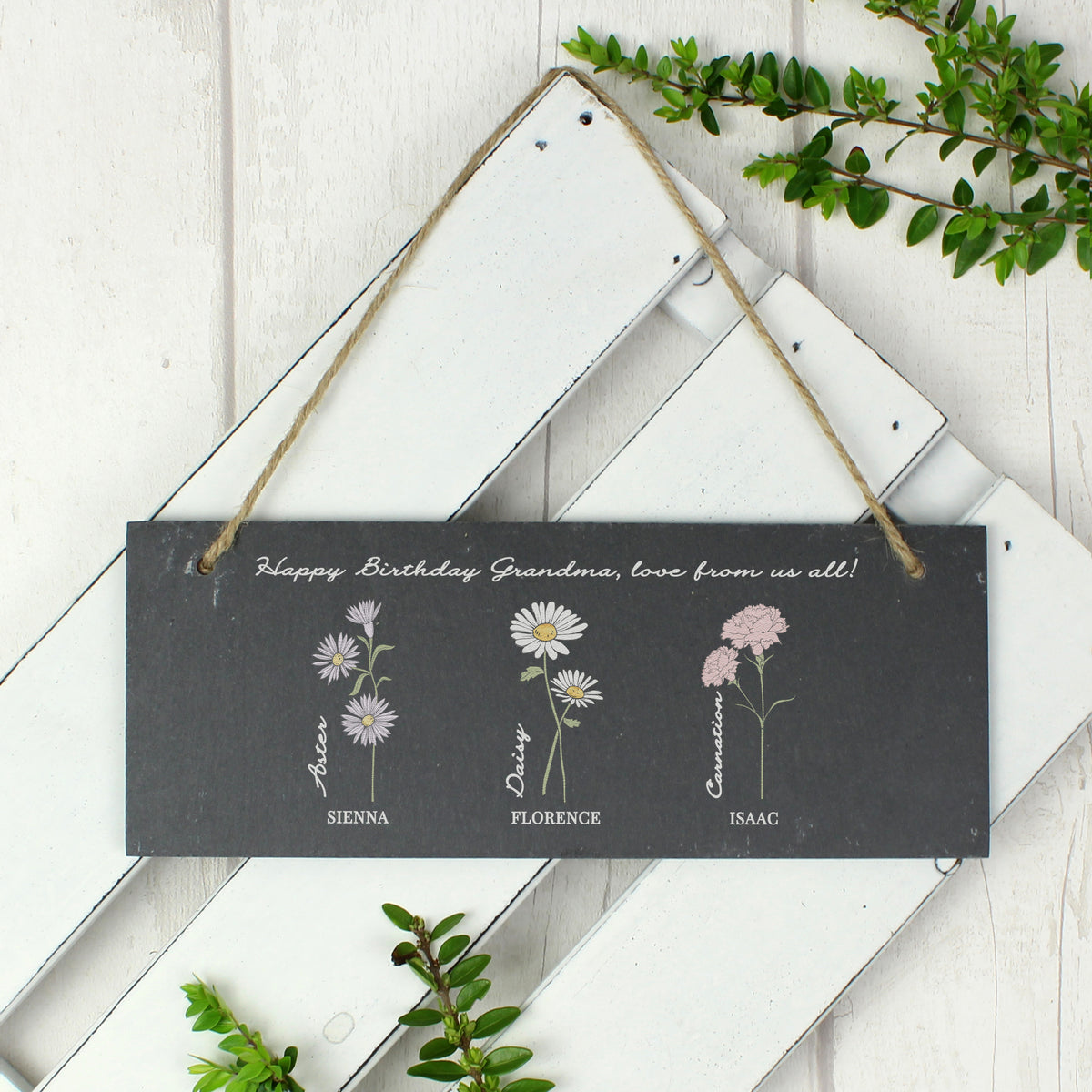 Decorative sign with floral illustrations and personalized text on a wooden background
