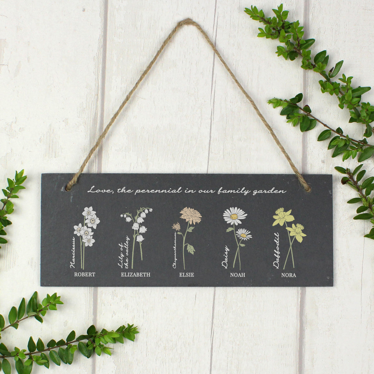 Decorative sign with floral illustrations and text on a white wooden background