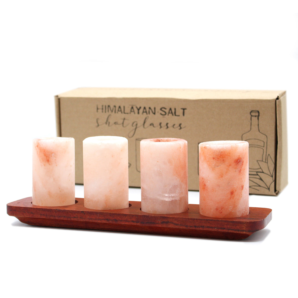 A set of four Himalayan salt shot glasses on a wooden tray, with each glass containing a small amount of pink Himalayan salt. The glasses are placed in front of a cardboard box labeled 'Himalayan Salt Shot Glasses'.
