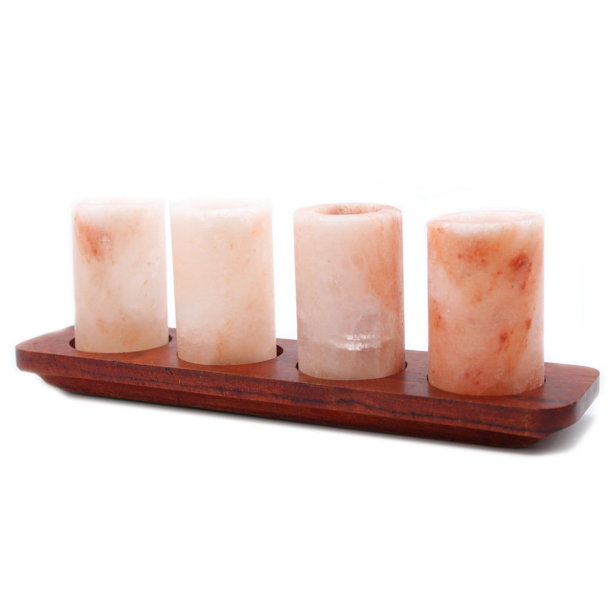 A set of four Himalayan salt shot glasses on a wooden tray, with each glass containing a small amount of pink Himalayan salt'.